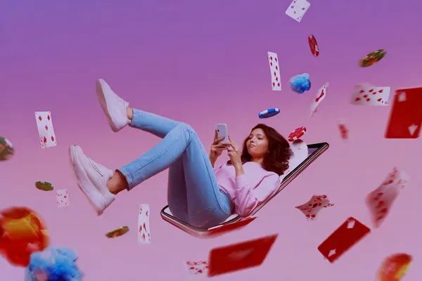 A young woman relaxing with her phone while dynamic casino elements float around her, illustrating the smooth mobile experience offered by the BETWINNER app.