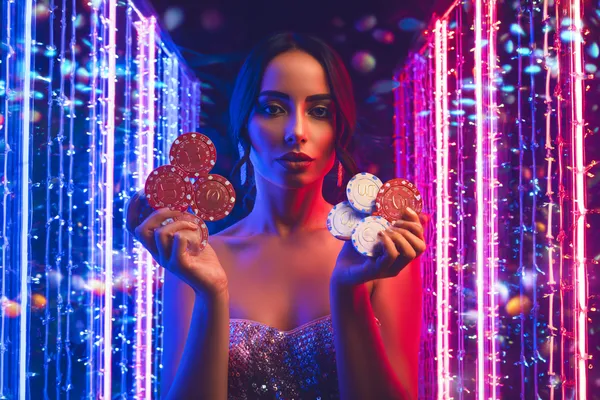 A cheerful woman in traditional clothing using her smartphone during a festive moment, showing how easily the BETWINNER app fits into everyday life.