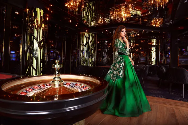 A professional dealer in a tuxedo greeting players at the roulette table, symbolizing the authentic live casino feel at BETWINNER.